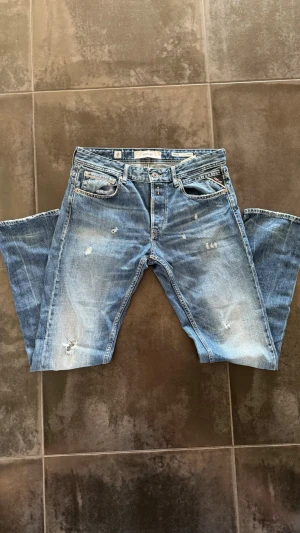 Replay Grover jeans - Säljer ett par Replay Grover jeans i blå med slitningar. Storlek 31W , ytterbens längd 101 cm (ca storlek 32).