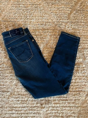 Jacob Cohen jeans - Hej jag säljer ett par Jacob Cohen jeans i riktigt snygg marinblå färg perfekt för dig som vill ha ett par kvalitetsjeans med grym passform. Nypris ≈5000!, mitt pris 749kr.  Skick: 9/10 Storlek: W30 Midja: 39cm Lår: 23cm Ytterlängd: 97cm Innerlängd: 74cm  Skriv gärna om du vill ha fler bilder eller har frågor!