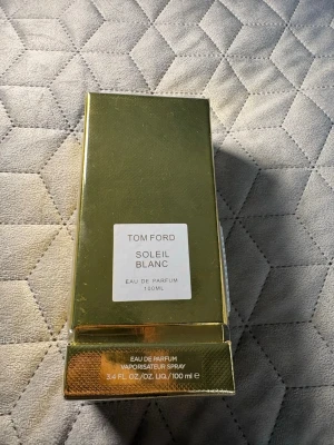 Tom Ford Soleil Blanc EdP 100ml - Lyxig parfym från Tom Ford, Soleil Blanc, i en elegant guldfärgad förpackning. Flaskan innehåller 100 ml Eau de Parfum och har en exklusiv och modern design som verkligen sticker ut. Perfekt för dig som gillar exklusiva dofter och snygga detaljer.