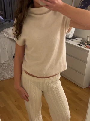 Beige stickad topp med kort ärm - Mysig beige stickad topp med korta ärmar och lös passform. 