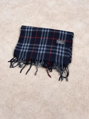 Rutig halsduk från Berberry - Mörkblå halsduk från Berberry i mjuk ull med klassiskt rutigt mönster i grått och rött. Halsduken har fransar i ändarna och en vävd logotypetikett. Perfekt accessoar för att lyfta din outfit.