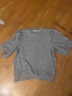 Grå tröja från 157 - Mysig grå tröja från 157 med  rund halsringning. Tröjan har en rak passform och är tillverkad i ett mjukt material som passar perfekt för kyligare dagar. Enkel men trendig design som är lätt att matcha med olika outfits.