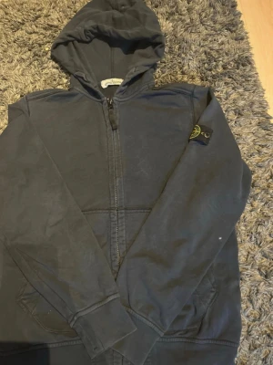 Stone Island hoodie - Se bilder för skick. Den är i storlek 156. Den är marinblå. Den är lite solblekt.