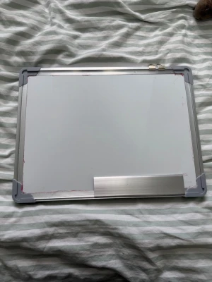 Magnetisk whiteboard med aluminiumram - Praktisk och stilren whiteboardtavla i gott skick! Perfekt för skola, arbete, hemmet eller planering. Tavlan har en robust aluminiumram med skyddande hörn, en smart pennhylla och upphängningsfästen för enkel montering. Den släta ytan är lätt att skriva på och ännu lättare att sudda – perfekt för anteckningar, scheman, studier eller kreativt arbete. Ett måste för dig som vill organisera vardagen på ett enkelt och effektivt sätt! Pennor o sudd ingår. Även väldigt bra skick även om denne lite använ