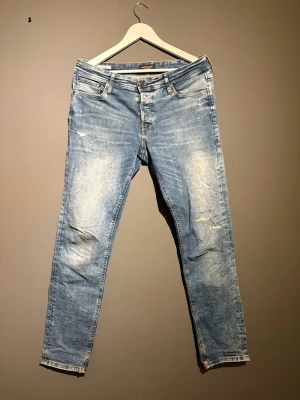 Ljusblå slitna jeans från Jack & Jones - Ljusblå jeans från Jack & Jones med snyggt slitna detaljer. Jeansen har raka ben med ljusa partier framtill och bak. Tillverkade i bomull med en bekväm passform.