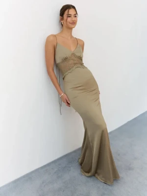 Balklänning med spetsdetaljer - Helt ny, slut på hemsidan. Elegant grön långklänning med tunna axelband, spetsdetaljer vid midjan och öppen rygg. Klänningen har en figurnära passform och är tillverkad i ett glansigt material som ger en lyxig känsla. Perfekt för speciella tillfällen.