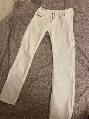 Vita Bootcut jeans diesel  - Snygga vita jeans från Diesel med bootcut passform och klassisk femficksdesign. Jeansen har bälteshällor och subtila detaljer vid fickorna. Säljer för de är för små