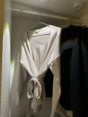 Beige omlottkofta  - Säljer denna fina omlottkoftan som passar perfekt nu i säsongen men även nu inpå våren. Koftan är från Object och är väldigt bra skick, endast använd två gånger och är som nyskick. Köptes för 600kr och säljer endast för 370 kr. Kom privat för fler bilder osv 🥰