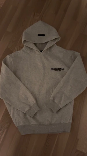 Grå Essentials hoodie - Säljer min grå Essentials hoodie som är i storlek S men den var lite Oversized för mig som har S så den skulle passa folk med storlek M 