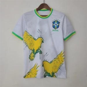 Vit Brasilien fotbollströja med fåglar - Säljer en vit fotbollströja från CBF Brasilien med gröna och gula detaljer på krage och ärmslut. Tröjan har tryckta gula fåglar och Brasilien-logga på bröstet. Perfekt för dig som vill sticka ut på planen eller heja på landslaget.