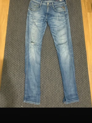 Blå replay Anbass slim fit jeans  - Snygga blå slim fit jeans med lätt tvättad look. Klassisk femficksmodell med dragkedja och knapp i midjan. Jeansen har en modern passform och är perfekta för en avslappnad stil. W30 L32