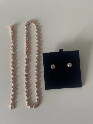 Swarovski Angelic set i roséguld - Vackert och glittrande set från Swarovskis klassiska kollektion Angelic. Designen är tidlös och elegant, pläterad i roséguld och smyckad med klara kristaller som ger en lyxig känsla.  Passar perfekt både till vardags och fest, eller som en fin present då allt ligger i sina originalaskar.