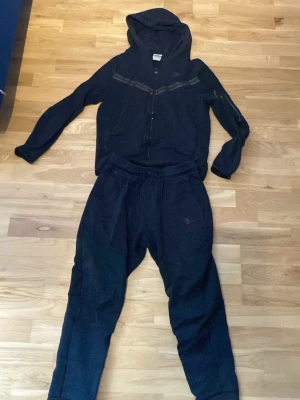 Nike tech set - Svart Nike tech set! Dragkedjan går tyvär ej att dra ner längre än man ser på bild 3. Men man kan fortfarande dra den över huvudet som en hoodie 😄