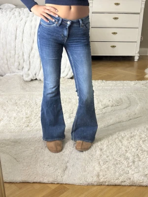 Blå bootcut jeans från weekday  - Säljer ett par low waist bootcut jeans ifrån weekday i väldigt bra skick💞