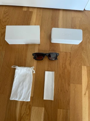 Bruna solglasögon CHIMI Core 03 - Snygga solglasögon från CHIMI, modell Core 03 i brun färg. De har en klassisk, fyrkantig form och levereras med originalförpackning, fodral och putsduk. Perfekta för dig som vill ha en stilren accessoar med modern känsla. Endast använt en sommar. Priset är förhandlingsbart vid snabb affär.