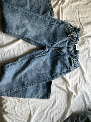 Blå raka jeans i klassisk modell - Ett par blå jeans i klassisk rak modell med normal midja. Jeansen har fem fickor och är tillverkade i denim. Perfekta för en avslappnad och tidlös stil.