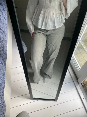 Låga grå jeans  - Ett par lågmidjade jeans ifrån Gina Tricot, storlek 38  Använda med lätt slitage längst ner vid sömmen på benen, annars i väldigt bra skick 