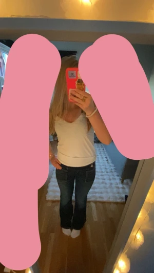 Mörkblå bootcut jeans - Säljer ett par mörkblå bootcut jeans med klassisk femficksdesign och låg midja. Jeansen har en snygg tvätt och sitter tajt över låren innan de blir vidare nertill. Perfekta för en trendig och avslappnad look.