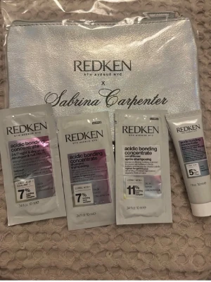 Redken x Sabrina Carpenter kit - Kit med Redken Acidic Bonding Concentrate-produkter i miniformat, inklusive schampo, balsam, leave-in och nattserum. Kommer i en snygg, skimrande necessär med texten 'Redken x Sabrina Carpenter'. Perfekt för resan eller att testa nya hårvårdsprodukter.