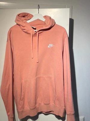 Nike hoodie  - Snygg hoodie från Nike. Klassisk modell med huva och dragsnören, stor magficka framtill och Nike-logga i vitt på bröstet. Perfekt för en avslappnad och trendig look. Mjuk bomullsblandning som känns skön mot huden.