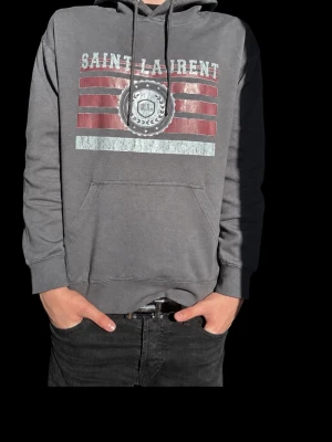 Saint laurent hoodie - Tjenaret! Jag säljer nu den här fina saint laurent hoodie som är i helt nytt skick. Den har inga täcken på skador eller fläckar! Den är i storlek M men funkar med som S om de skulle va så. Den är i 10/10 skick✅ Väldigt populär nu till sommaren. Köpte den för 5000kr och mitt pris är 1399kr 😉 Priset kan ju alltid diskuteras om de skulle va så! Tveka inte på att höra av dig om de skulle va något du undrar😁  //Lowe