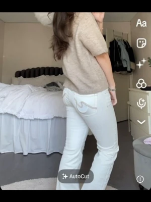 Vita bootcut jeans från Nelly - Säljer ett par vita bootcut jeans med snyggt broderat mönster på bakfickan💗