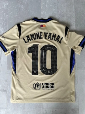 Lamine Yamal Barcelona fotbollströja  - Snygg FC Barcelona-tröja som passar perfekt till vardags. Med Lamine Yamal på ryggen – en av Barcelonas största stjärnor. Tröjan är endast använd några gånger och är i fint skick. Storlek S, men passar även XS.