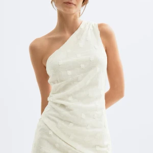 Vit oneshoulder topp med blommönster - Superfin vit topp med oneshoulder-design och diskret blommönster. Tunt, lätt material som ger en luftig känsla och snygg drapering. Perfekt för dig som vill sticka ut med en unik och trendig topp. Oanvänd men tagit av lappen🫶🏼