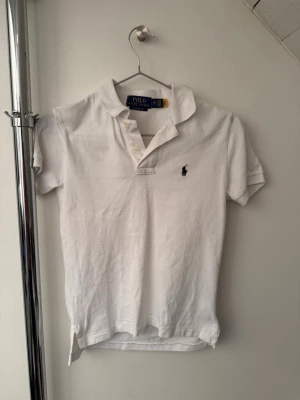 Vit polo pikétröja  - Tjabba! Säljer nu denna vita polo pikén i storlek 8år! Den är i ett nytt skick, inga defekter! Bara att höra av sig om ni har några tankar eller funderingar!😄