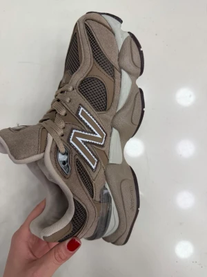 Bruna New Balance 2002R sneakers (finns i storlek 37-40) - Chunky sneakers från New Balance i modellen 2002R. Skorna är bruna med meshpaneler och detaljer i mocka och syntet. Stort vitt N på sidan och robust sula med grå och mörkbruna inslag. Perfekta för en sportig och trendig look.