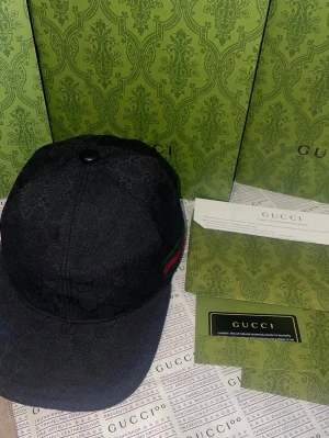 Gucci keps  - En vacker Gucci keps i den svarta färgen oanvänd tagen är på med följer box papper alla tillbehör förutom kvitton 