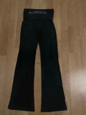 utsvängda leggings - Utsvängda folded yogapants från Gina Tricot med strass på baksidan där det står Ma chérie  storlek 134/140 saknar runt 3 stenar men det syns knappt (se sista bilden)  obs katt finns i hemmet!🐈‍⬛