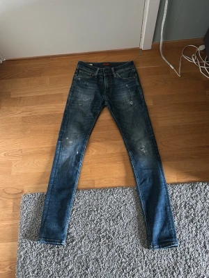Mörk blåa jeans från jack&jones - Hej! Jag säljer mina mörkblåa jeans från Jack&Jones med slitningar, Byxorna är aldrig andvända! Det är W28 L30