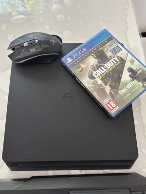 PlayStation 4 Slim med Call of Duty - Svart PlayStation 4 Slim med stilren, matt finish. Konsolen är fyrkantig och kompakt. Medföljer gör ett svart gaming-tangentbord, en svart gaming-mus med futuristiskt mönster samt spelet Call of Duty: Infinite Warfare Legacy Edition till PS4.
