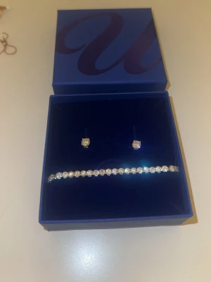 Set äkta silver, örhänge och tennisarmband  - Vackert presentset i 925 Sterling silver. Detta silverset består av ett tennisarmband och studs dekorerade med vita Kubisk Zirkonia.  Oanvända, ej urtagna från asken ens.  Perfekt att ge som present på mors dag, skolavslutning/student/examen.  Asken medföljer såklart.
