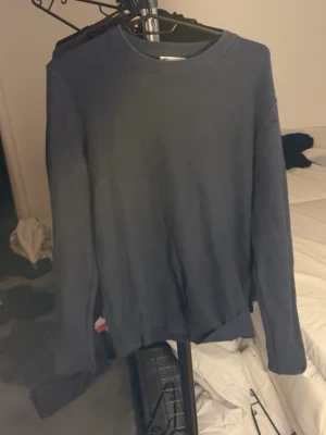 Mörkblå basic tröja med rund hals - En stilren mörkblå tröja med rund halsringning och långa ärmar. Tröjan har en enkel och klassisk design utan synliga loggor eller mönster, perfekt för en clean look. Materialet ser ut att vara mjukt och bekvämt, passar bra till jeans eller chinos.