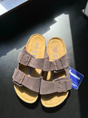 Birkenstock Arizona mockasandaler - Birkenstock Arizona sandaler i mjuk mocka med två breda remmar och justerbara metallspännen. Helt nya och oanvända .