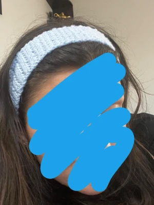 Ljusblå virkat hårband - Supergulligt ljusblått hårband som är virkat för en mysig och trendig look. Hårbandet knyts baktill och är gjort i mjukt garn, perfekt för att hålla håret på plats och ge en söt touch till din outfit.