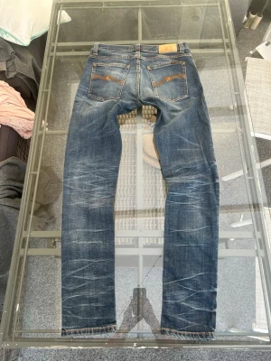 Nudie Jeans Tight Terry W32/L34 – faded denim jeans - Säljer ett par riktigt feta Nudie Jeans Tight Terry i storlek W32/L34. Grym mörkblå wash med naturliga fades och distressed detaljer som ger en clean vintage- och streetwear-look. Tight/slim fit med stretch så de sitter riktigt bra.  Passar perfekt till sneakers, hoodie, zip hoodie eller stickat för en clean casual fit. Ekologisk bomull med elastan för extra komfort. Riktigt snygga detaljer och bra fade över hela jeansen.  • Nudie Jeans Tight Terry • Storlek W32/L34 • Slim/tight fit • Dark wash 