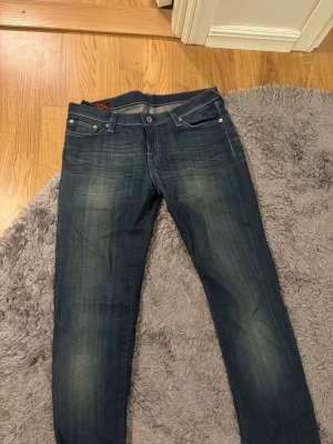 Mörkblå Evisu jeans - Säljer dessa feta mörkblå jeans från Evisu. Jeansen är unika och perfekt till dig som vill sticka ut lite. Dom är slim fit och har riktigt feta detaljer så som patchen och loggan på bakfickorna. Uppsydda till mig som är ungefär 183 men bara använda 2 gånger då ja inte diggade passformen. Har kvar papperslappen som satt i bakfickan som bevis på att dom är ”nya”. Bara att skriva om intresserad!