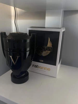 Paco Rabanne Invictus Victory Elixir - Snygg parfymflaska i form av en svart trofé från Paco Rabanne, Invictus Victory Elixir. Flaskan har guldiga detaljer och känns riktigt lyxig. Kommer med originalkartong. Perfekt för dig som gillar exklusiva dofter och cool design. Nypris ~ 1 150kr, jag säljer lite mer än hälften för 500kr. Pris går o diskutera 