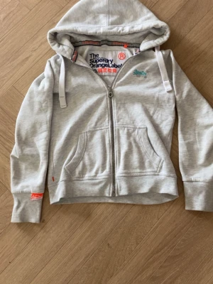 Superdry orange label - Säljer min superdry hoodie som är riktigt fräsch och i otroligt bra skick den sitter bra på mig som är 182 men hade passat allt från 170-185 ksk till o med ifall du är kortare beroende på passform om du vill ha mer bilder eller specifika bilder med den på eller likande så är det bara att skriva. Priset är milt diskuterbart vid snabb affär!