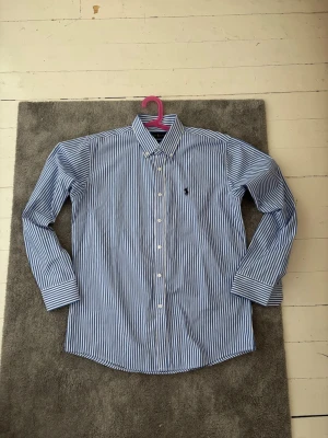 Ralph Lauren Skjorta - Säljer denna somriga polo skjortan. Knappt använd, storlek L men kan även passa storlek M.  Skriv vid funderingar!