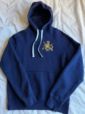 Marinblå hoodie från Polo Ralph Lauren - Snygg marinblå hoodie från Polo Ralph Lauren i storlek small, hoodien är allmänt använd men helt felfri. Perfekt till sommarkvällar!