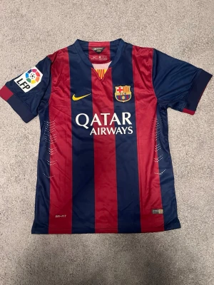 Barcelona Neymar Jr matchtröja - Säljer en officiell FC Barcelona matchtröja från Nike med Neymar Jr och nummer 11 på ryggen. Tröjan har blå och röda breda ränder, korta ärmar och tryckta loggor från Qatar Airways, LFP och UNICEF. Tillverkad i lätt och ventilerande polyester. R3plicka
