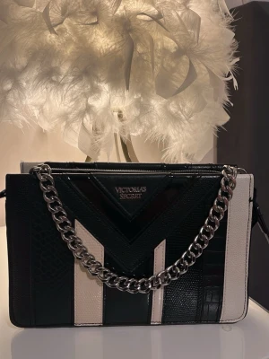Svart och vit handväska Victoria's Secret - Väldigt bra skick som ny, avtagbar bälte. Rymlig plats.