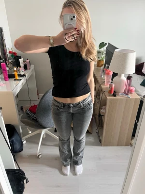 Grå low waist bootcut jeans - Säljer ett par gråa low waist jeans med bootcut passform. De är stretchiga i materialet och har resor i midjan som går att justera. De är i storlek 170 från Gina Tricot Young, men passar S/M. De är enbart använda ett fåtal gånger och är därför i fint skick! Pris kan diskuteras 🫰🏻