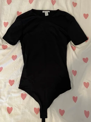 Svart kortärmad body från Amisu - Säljer en svart kortärmad bodysuit som är använd ett få antal gånger eftersom att den inte passar min stil längre, ifall du har några frågor så är det bara att fråga på❤️