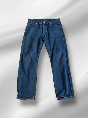 Weekday jeans - Klassiska blå jeans med rak passform och fem fickor. Jeansen har en enkel design utan synliga detaljer och är tillverkade i slitstark bomull. Perfekta för en avslappnad och tidlös stil. Modell: space relaxed straight jeans. Storlek 28/30.