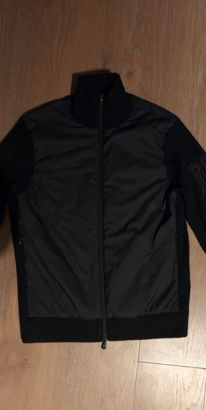 Hybrid jacka från J.lindberg - Snygg svart hybdrid jacka. Skikt 8/10 använd få gånger pga för att jag tröttnade. Passar både (S) och sitter lite tajtare för (M)